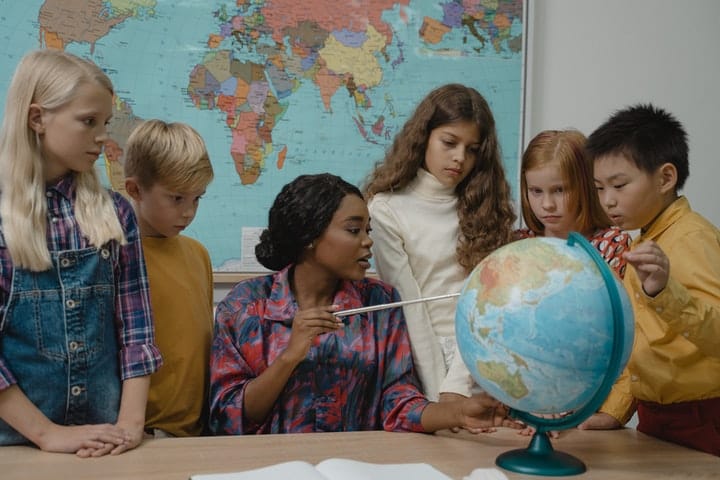 teacher with globe and students