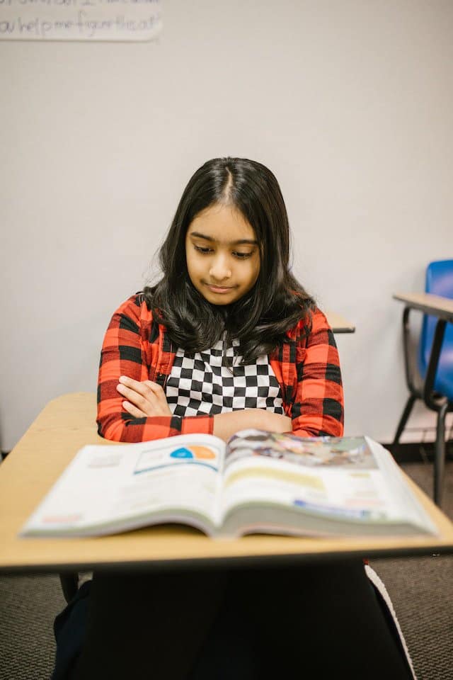 girl in checked shirt reading